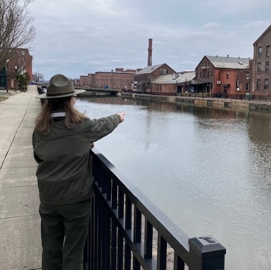 Visitor Services Supervisor Nancy Condon points out the Massasoit Paper Mill across the first level canal in Holyoke.