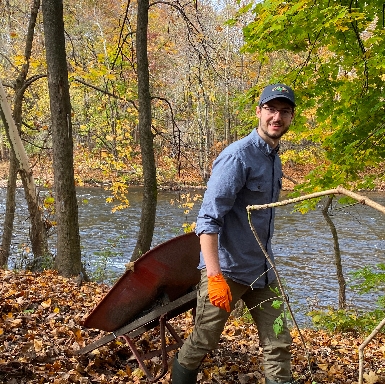 Volunteer Jake Lehan removes a wheelbarrow from the 2923 Levee cleanup