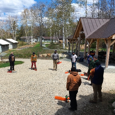 A group of people in a chainsaw training course at Camp Dodge Trails Center