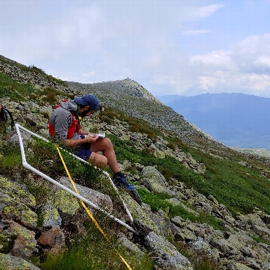 Staff Scientist Jordon Tourville conducting a plant survey using a quadrat. 