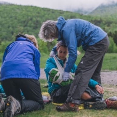 Wilderness First Aid trainees practice constructing an arm splint in a mock emergency scenario.